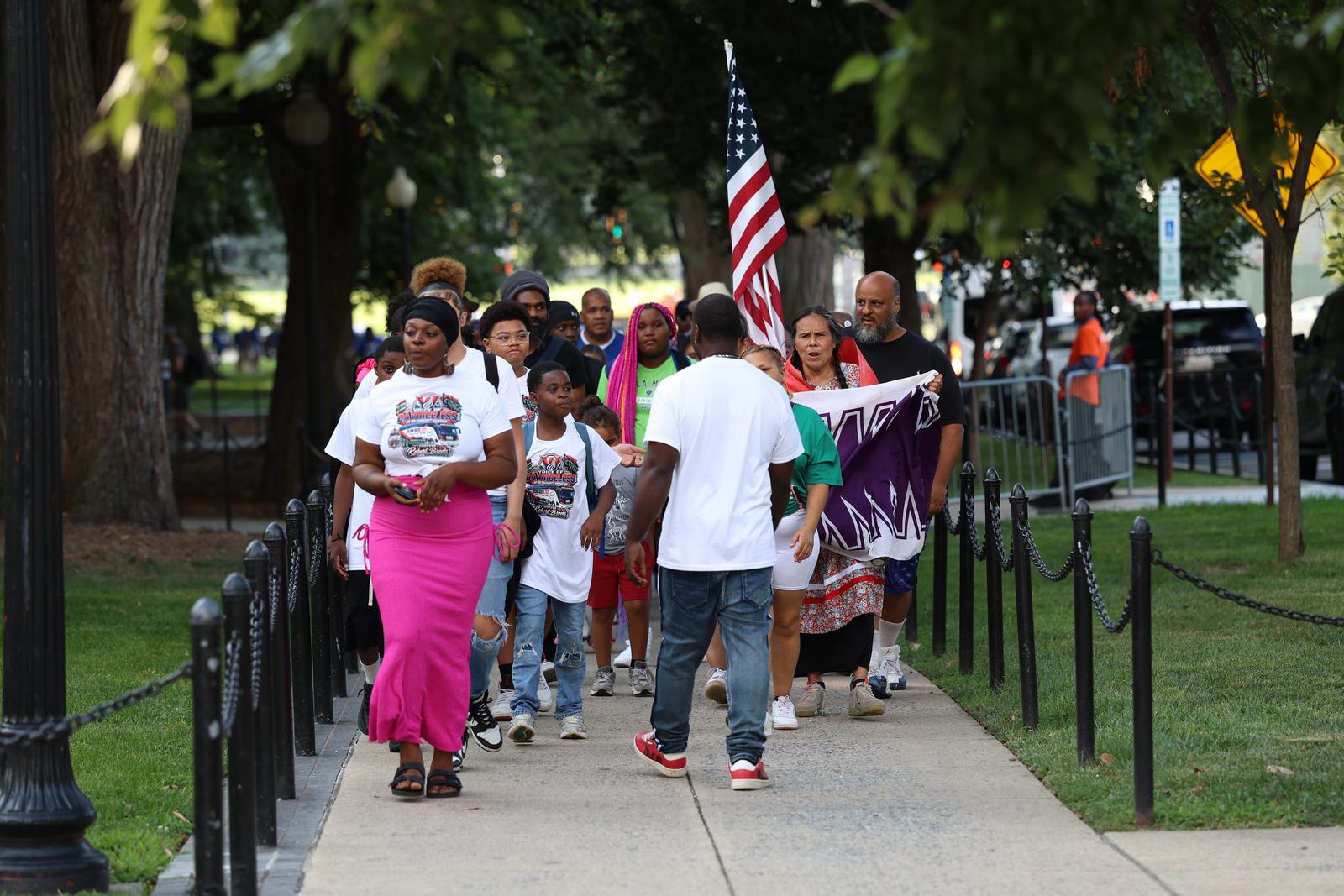 Marchers walking toward the Lincoln Memorial carrying an American flag.