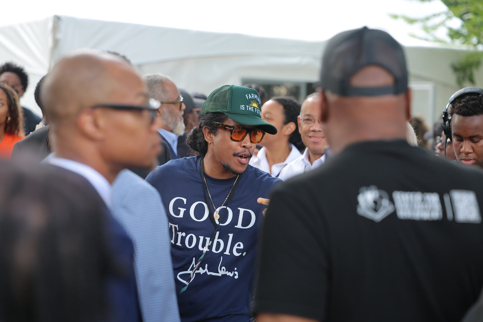 An attendee wearing a Good Trouble shirt honoring John Lewis, standing among organizers.